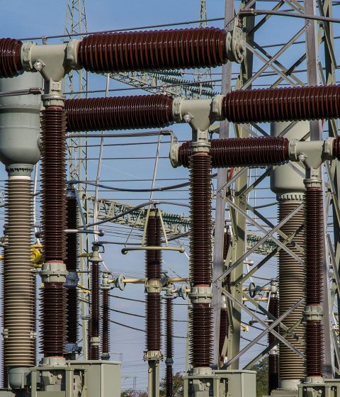 Detailed view of high voltage electrical substation with transformers and power lines.